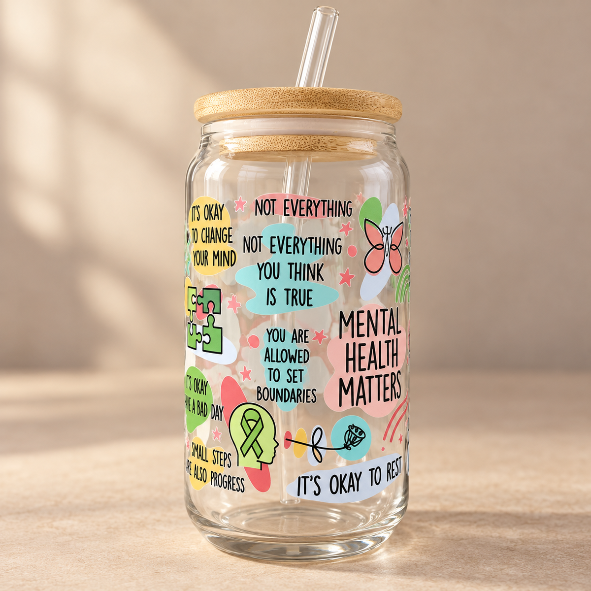 Close view of mental health affirmations printed around a clear glass tumbler