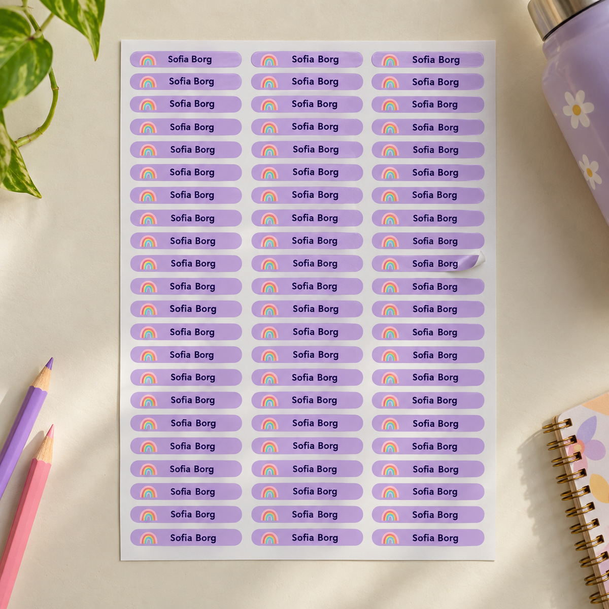 Full sheet of lilac personalised school name stickers with rainbow icon